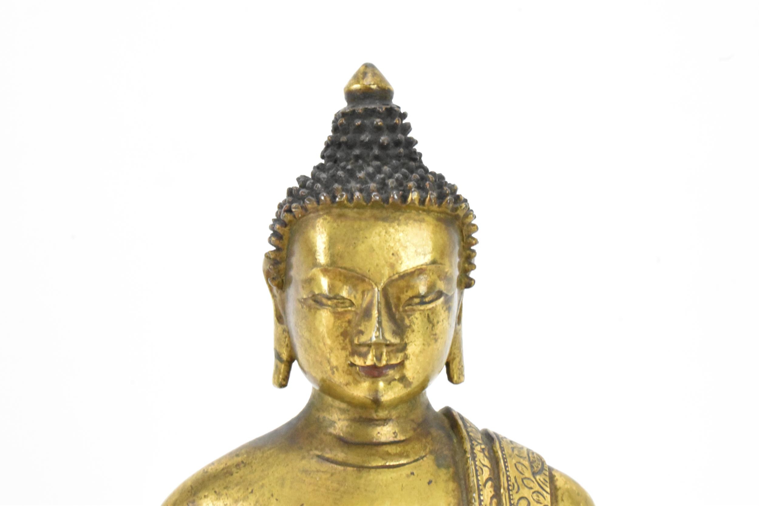 A Sino Tibetian gilt bronze figure of Buddha, 18th/19th century, dressed in monastic robe, with - Image 6 of 16