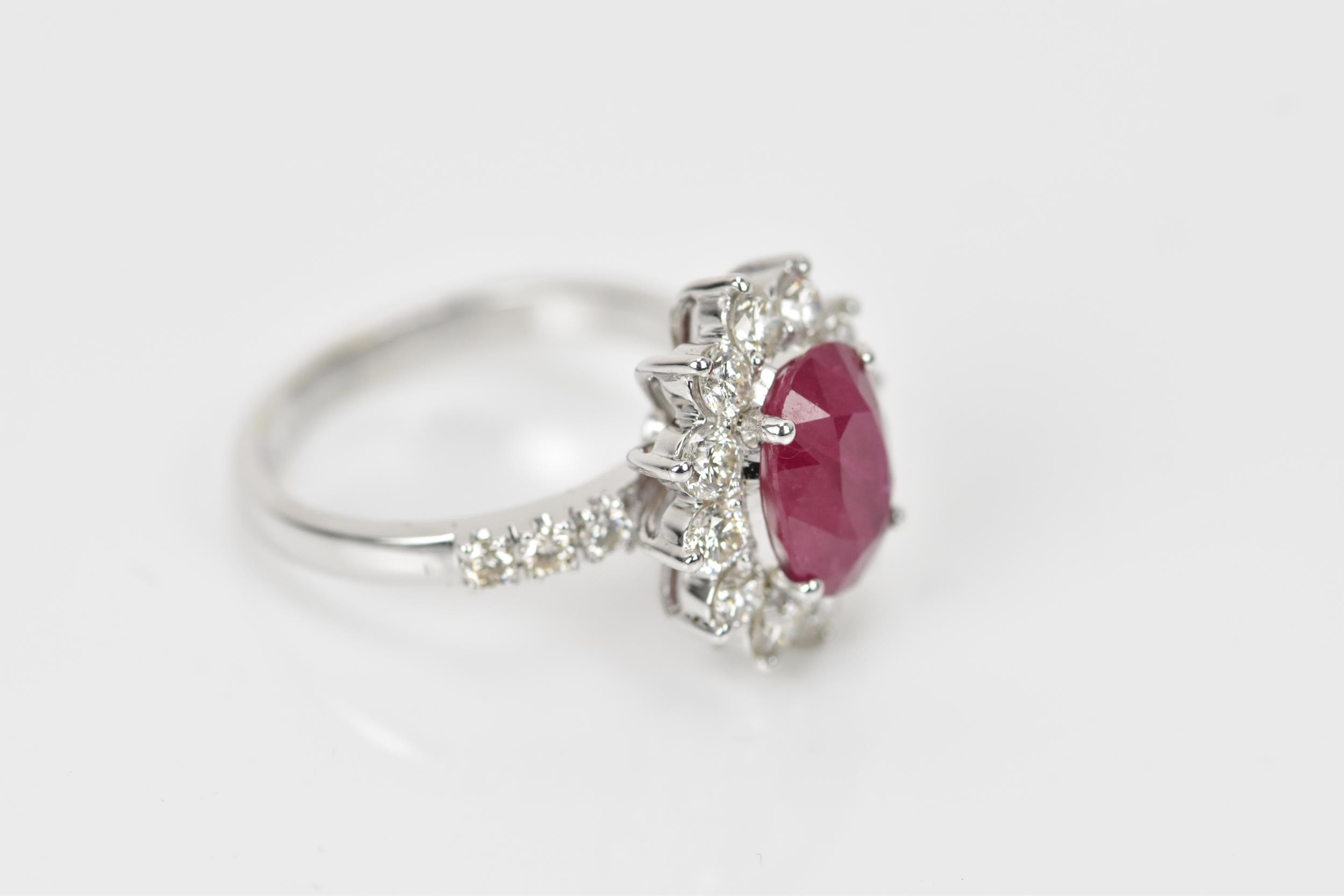 An 18ct white gold, diamond and ruby dress ring, set with central oval mixed cut ruby in four claw - Bild 5 aus 12