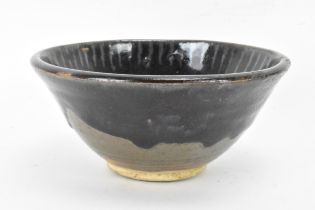 A Chinese Cizhou type bowl, of conical form and covered in a dark lustrous glaze falling short of