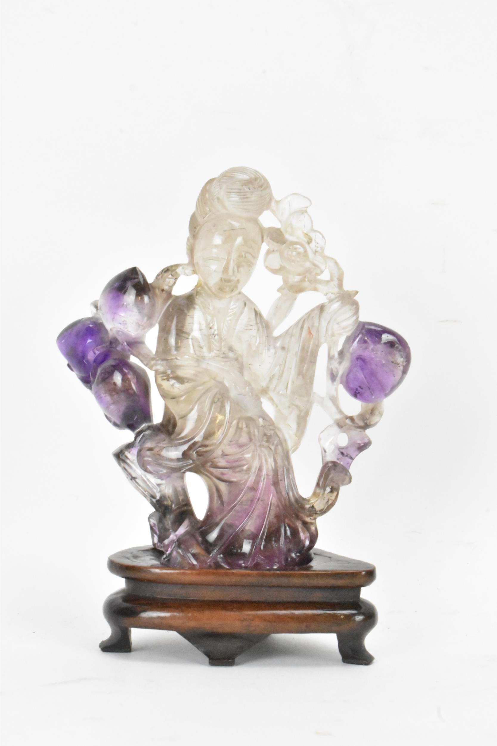 A 20th century Chinese carved amethyst figure of Guanyin, the goddess of mercy, in a seated position