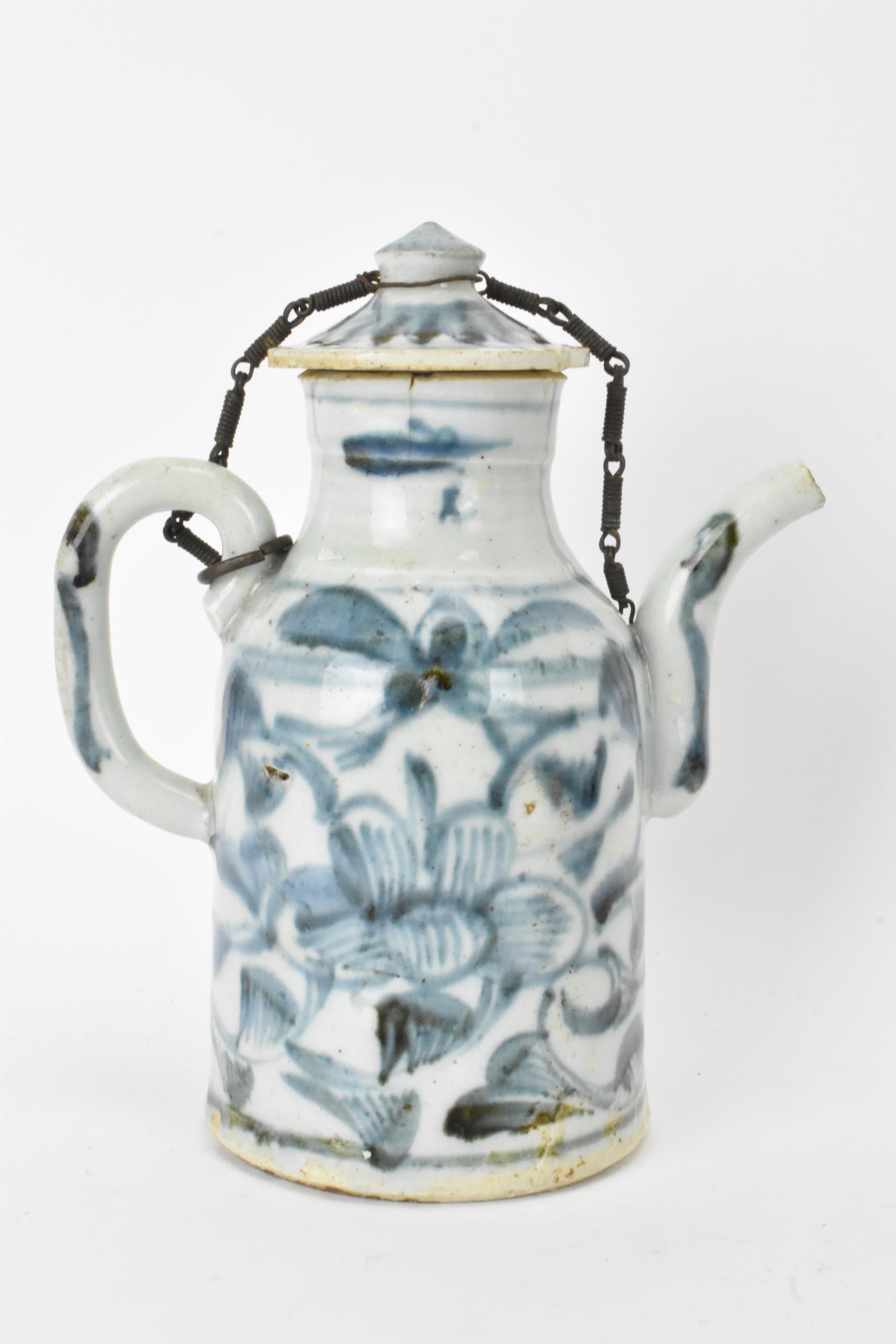 A Chinese ewer, late Ming dynasty, decorated in underglaze blue with flowers, loop shaped handle and