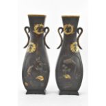 A pair of Japanese Meiji period iron vases, decorated with panels depicting birds and flowers in