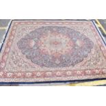An early 20th century handwoven Indian Agra rug, with central floral medallion on a navy ground,