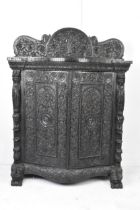 A 19th century Anglo Indian colonial black lacquered hardwood cabinet, serpentine fronted and