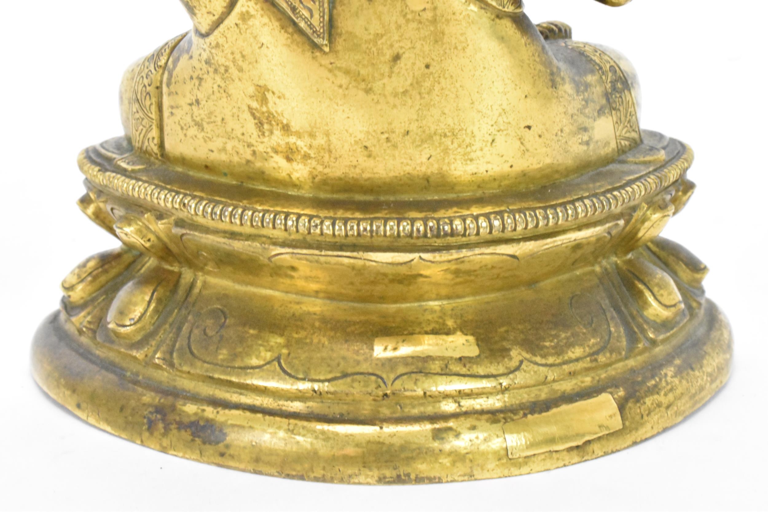 A Sino Tibetian gilt bronze figure of Buddha, 18th/19th century, dressed in monastic robe, with - Image 12 of 16