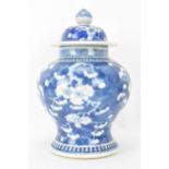 A Chinese prunus pattern blue and white vase, late Qing Dynasty, of baluster form with domed cover
