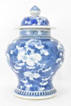 A Chinese prunus pattern blue and white vase, late Qing Dynasty, of baluster form with domed cover