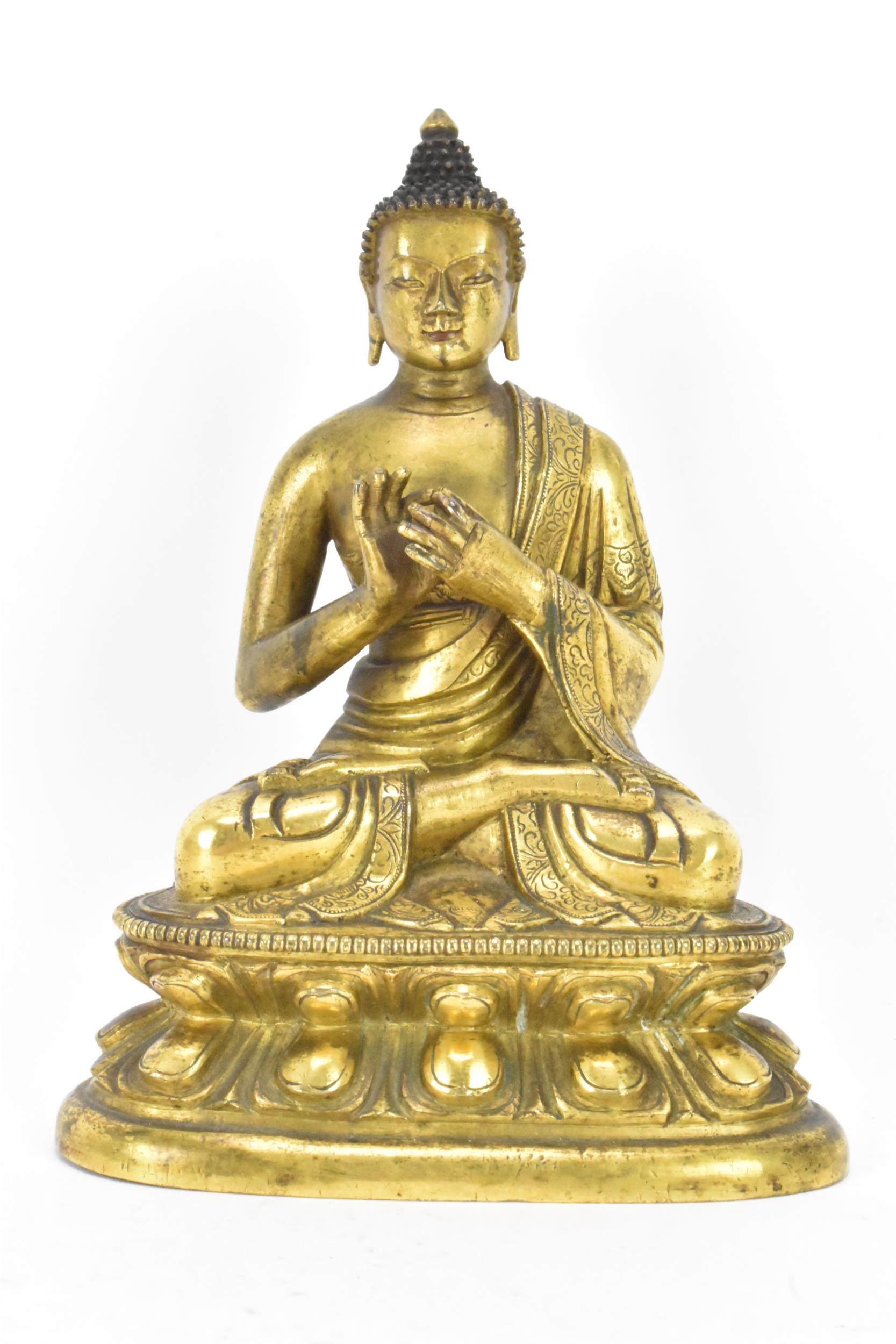 A Sino Tibetian gilt bronze figure of Buddha, 18th/19th century, dressed in monastic robe, with