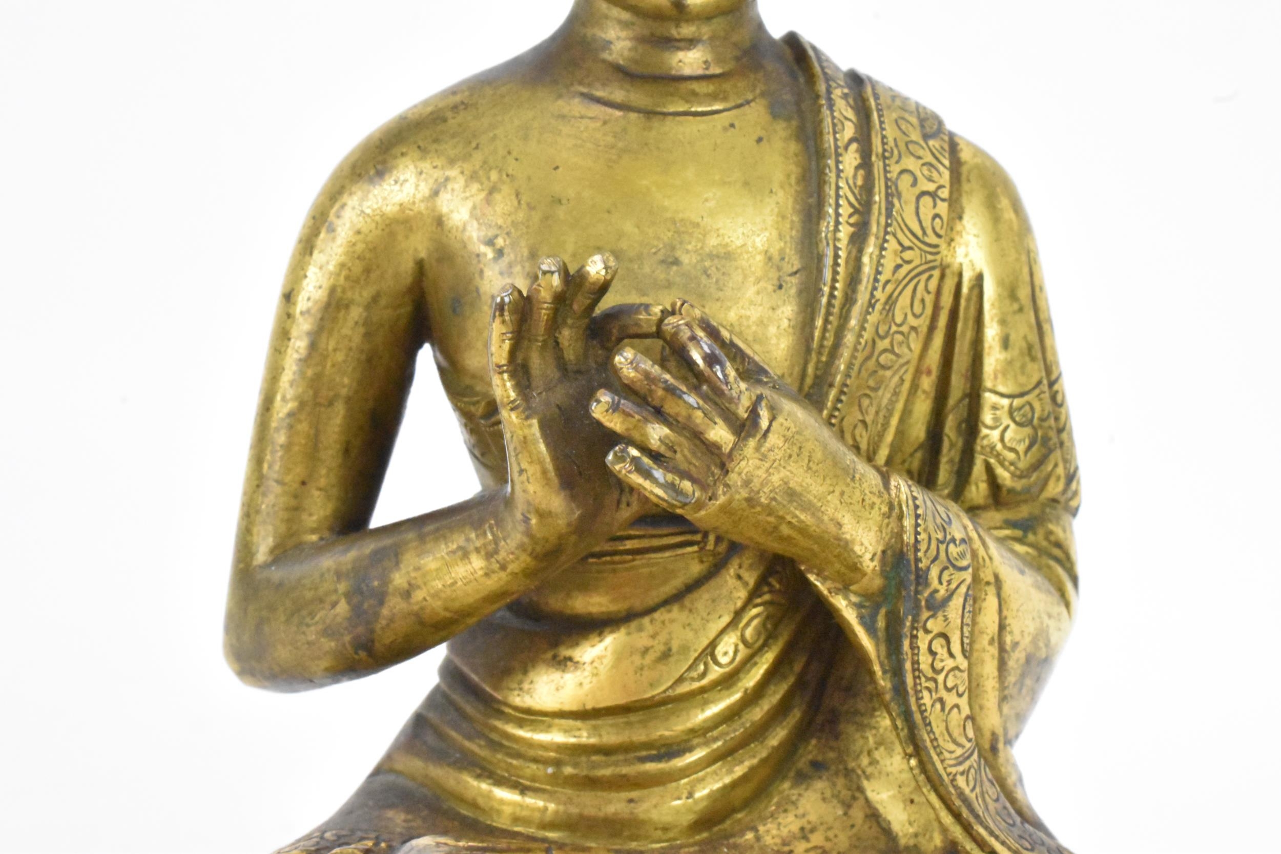 A Sino Tibetian gilt bronze figure of Buddha, 18th/19th century, dressed in monastic robe, with - Image 7 of 16