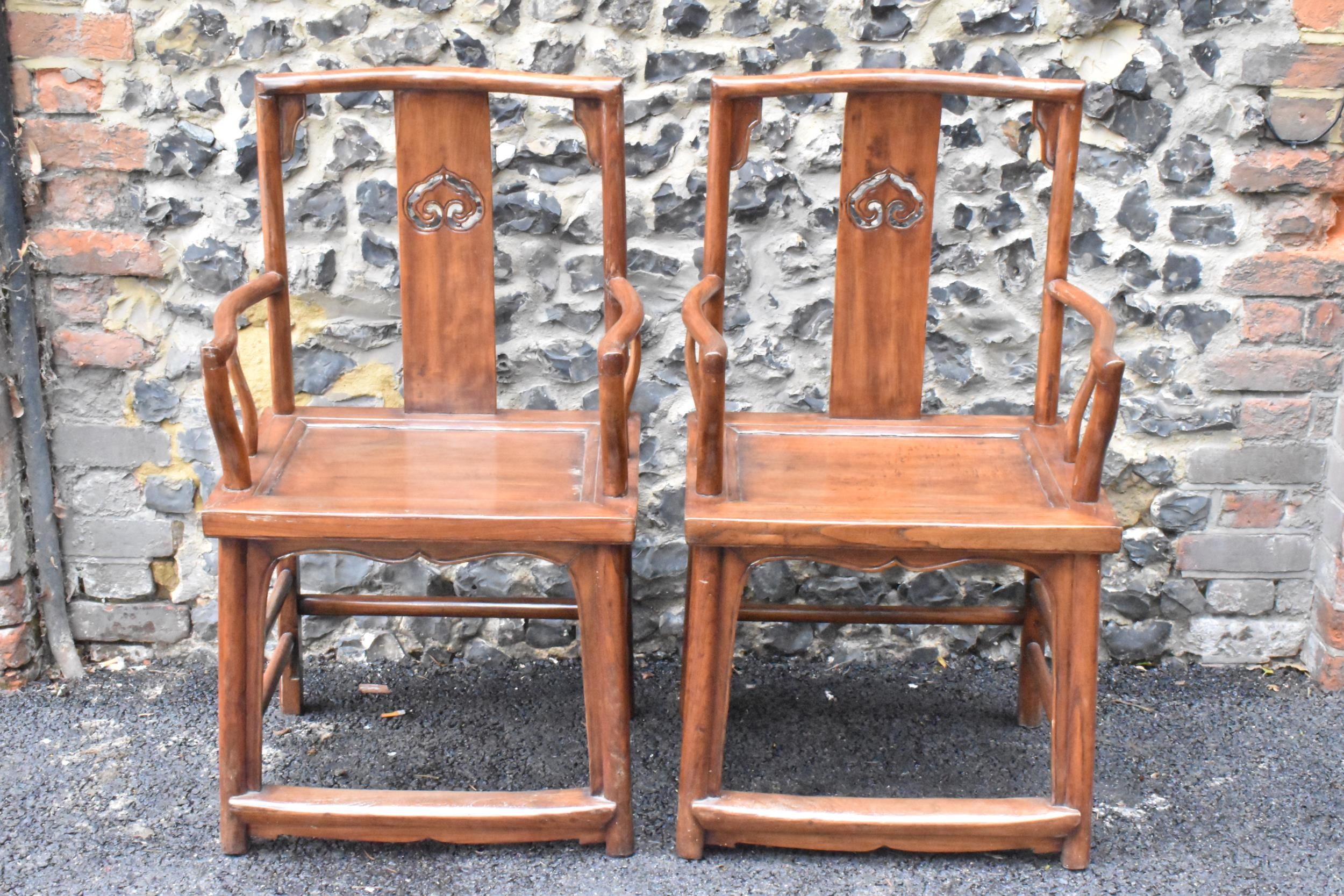 A pair of 20th century Chinese Ming style hardwood armchairs, with curved top rail and curved