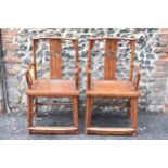 A pair of 20th century Chinese Ming style hardwood armchairs, with curved top rail and curved