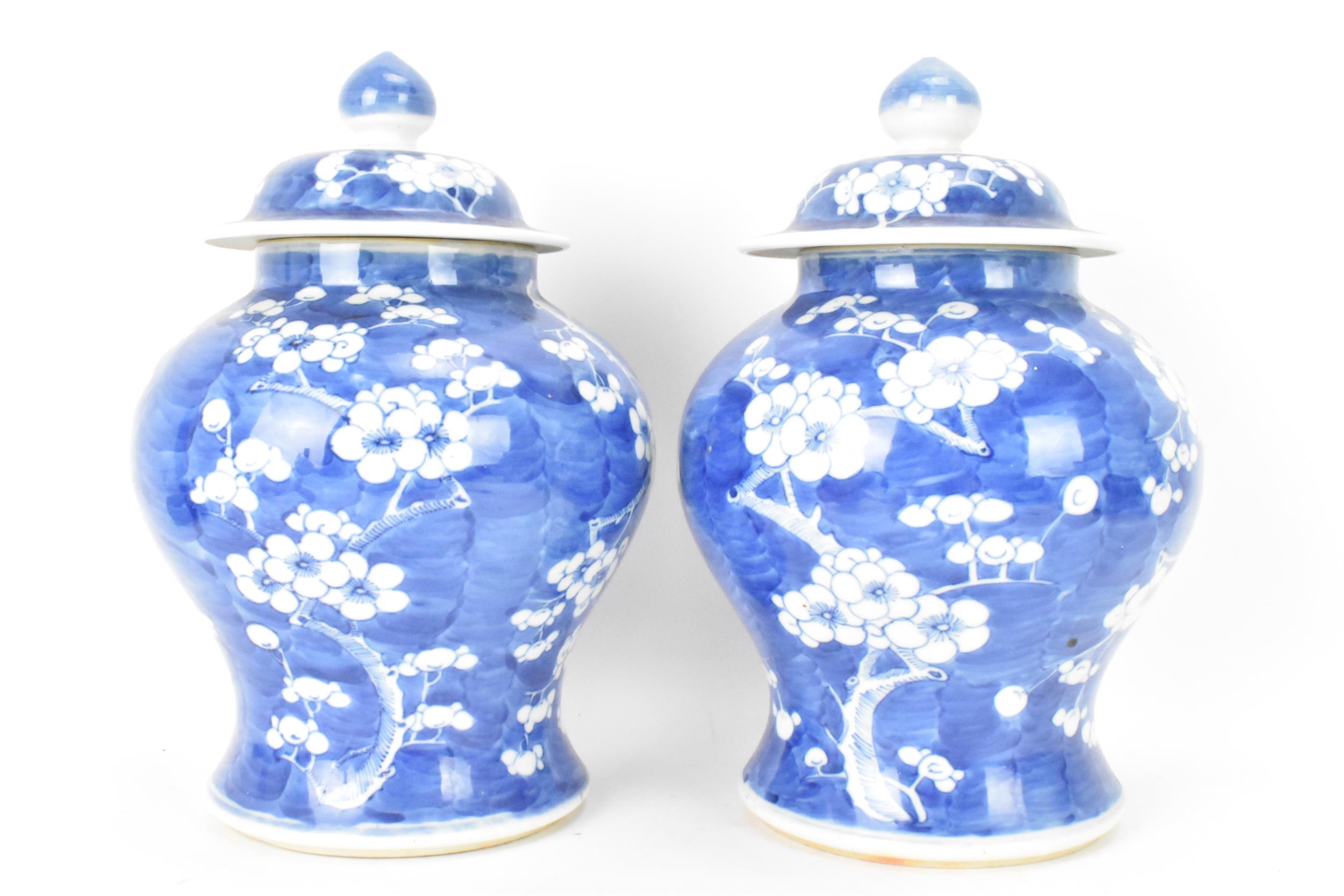 A pair of Chinese prunus pattern blue and white vases, late Qing Dynasty, both of baluster form with