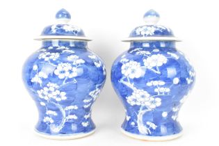 A pair of Chinese prunus pattern blue and white vases, late Qing Dynasty, both of baluster form with