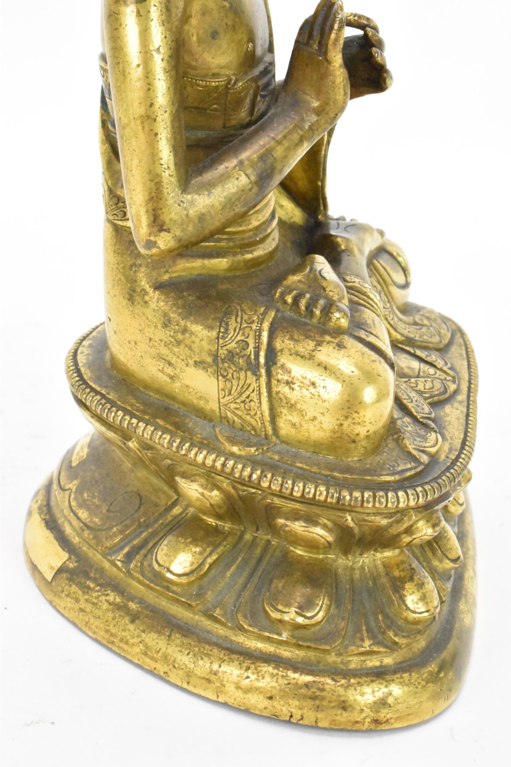 A Sino Tibetian gilt bronze figure of Buddha, 18th/19th century, dressed in monastic robe, with - Image 16 of 16