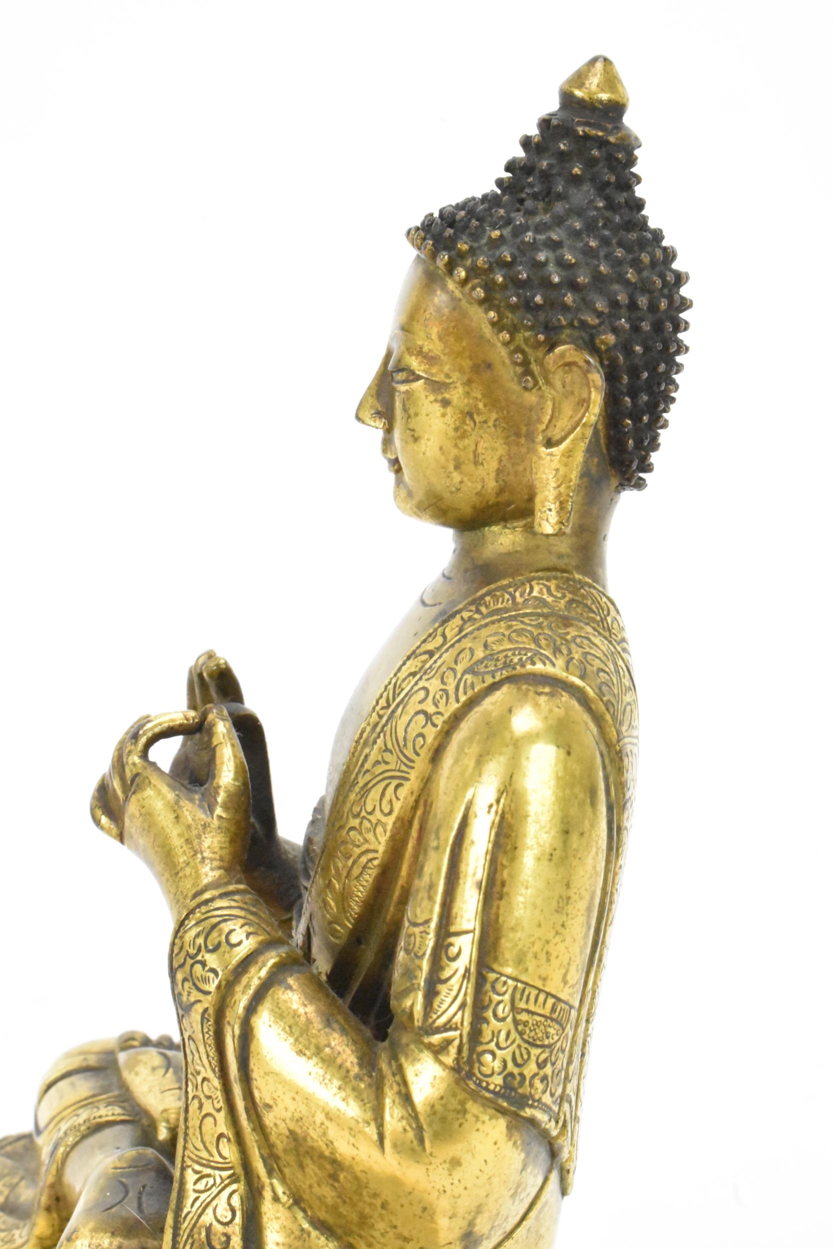 A Sino Tibetian gilt bronze figure of Buddha, 18th/19th century, dressed in monastic robe, with - Image 13 of 16