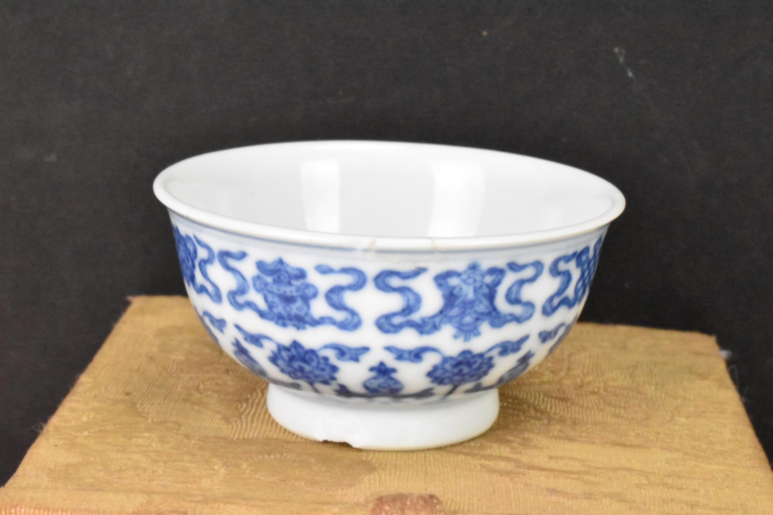 A Chinese blue and white tea bowl, decorated with lotus flowers among stylized scroll decoration - Image 2 of 6