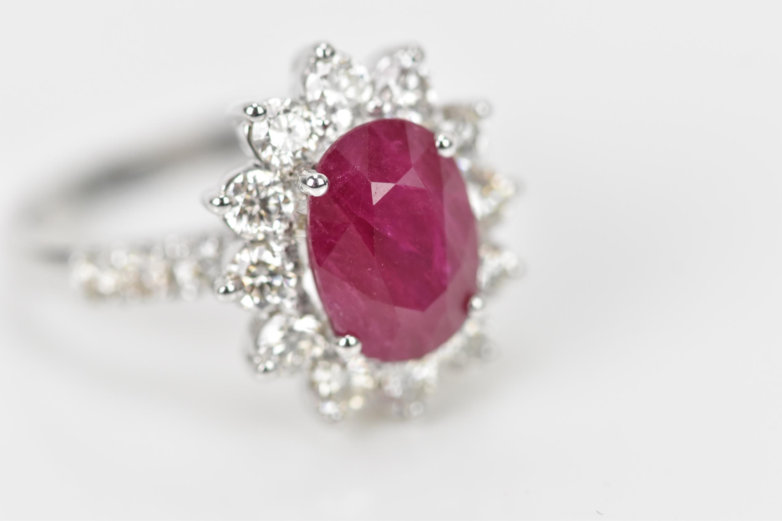 An 18ct white gold, diamond and ruby dress ring, set with central oval mixed cut ruby in four claw - Bild 2 aus 12