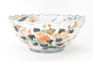 A Japanese Edo period Arita Imari porcelain punch bowl, circa 1700, having a shaped rim and fluted