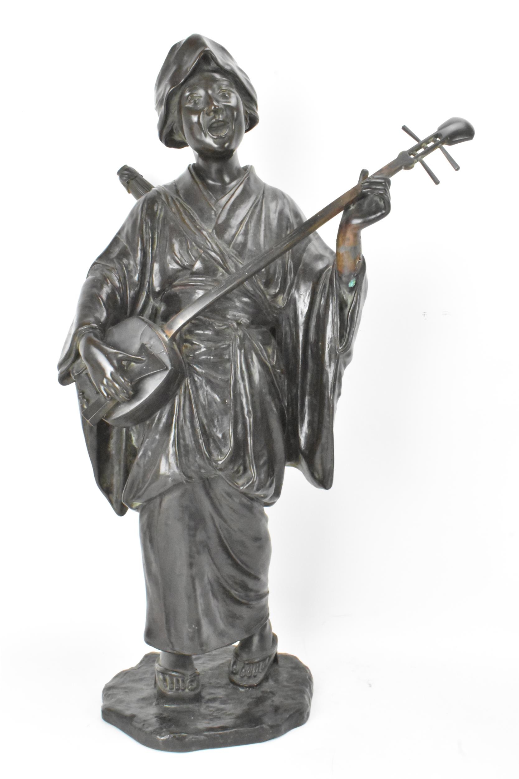 A Japanese Meiji period bronze figure of a bijin musician, wearing a kimono and playing a shamisen