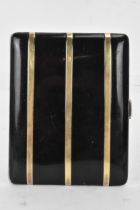 An early 20th century American sterling silver cigarette case, the cushion form case in black enamel