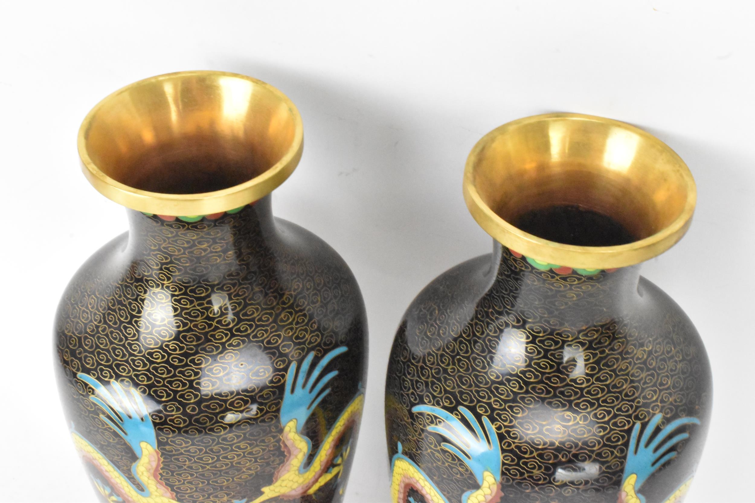 A pair of Chinese mid 20th century cloisonne vases and a bowl, all with black grounds decorated with - Image 6 of 12