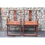 A pair of 20th century Chinese Ming style hardwood armchairs, with curved top rail and curved