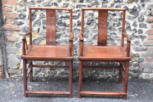 A pair of 20th century Chinese Ming style hardwood armchairs, with curved top rail and curved