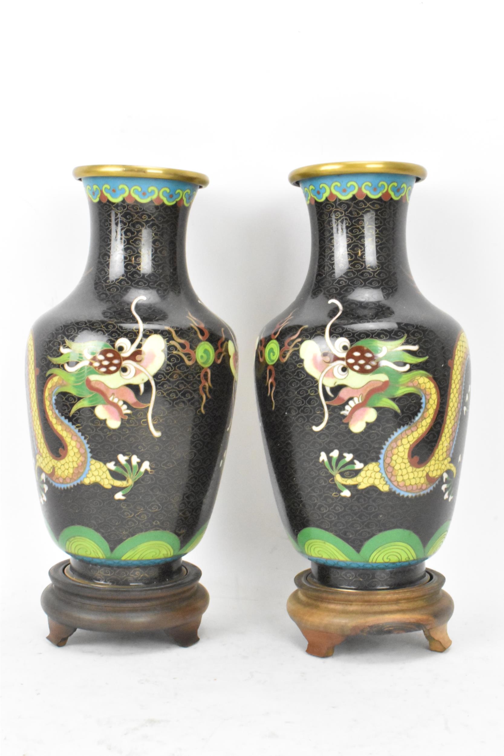 A pair of Chinese mid 20th century cloisonne vases, with black grounds decorated with confronting