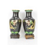 A pair of Chinese mid 20th century cloisonne vases, with black grounds decorated with confronting