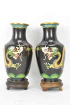 A pair of Chinese mid 20th century cloisonne vases, with black grounds decorated with confronting