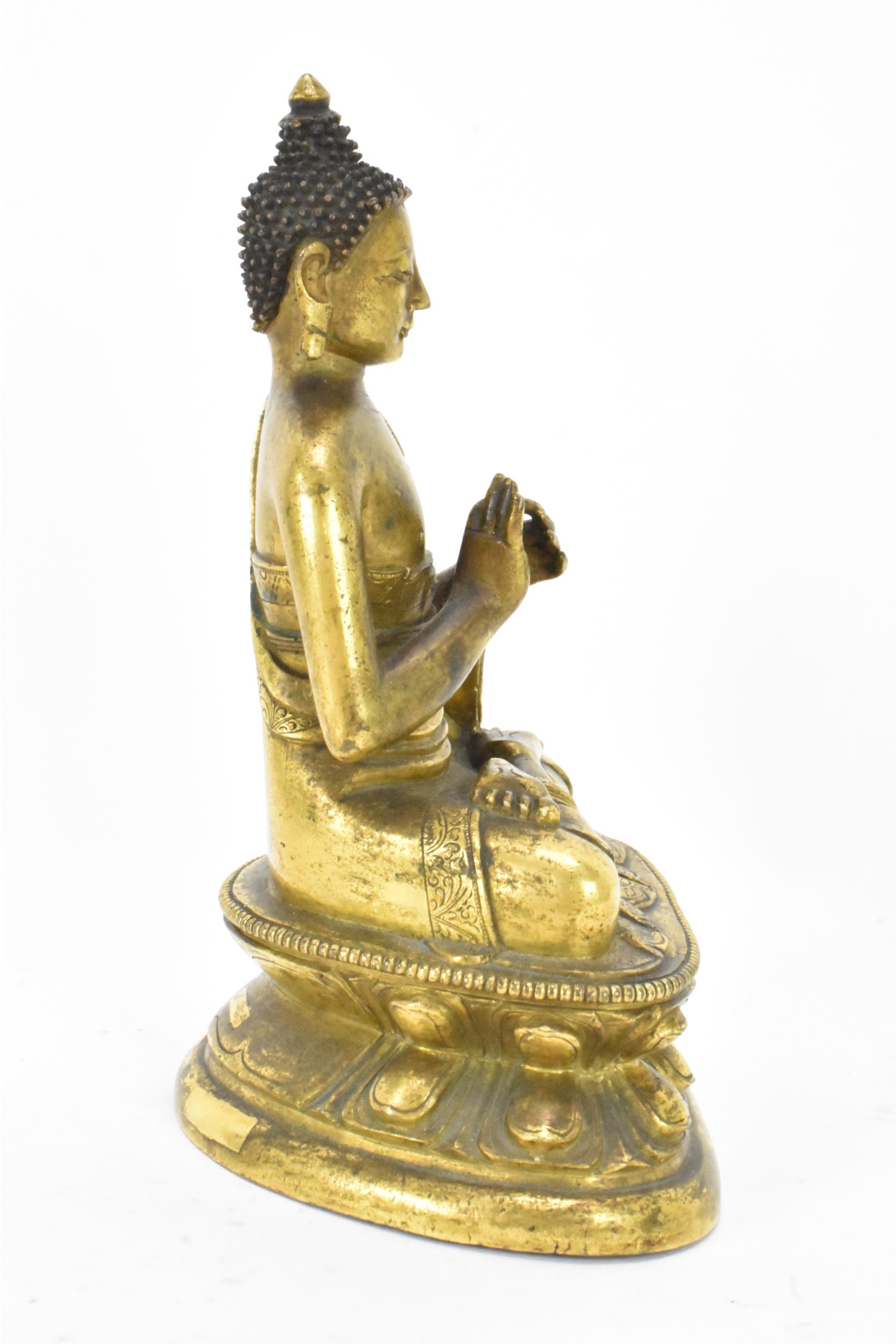 A Sino Tibetian gilt bronze figure of Buddha, 18th/19th century, dressed in monastic robe, with - Image 4 of 16