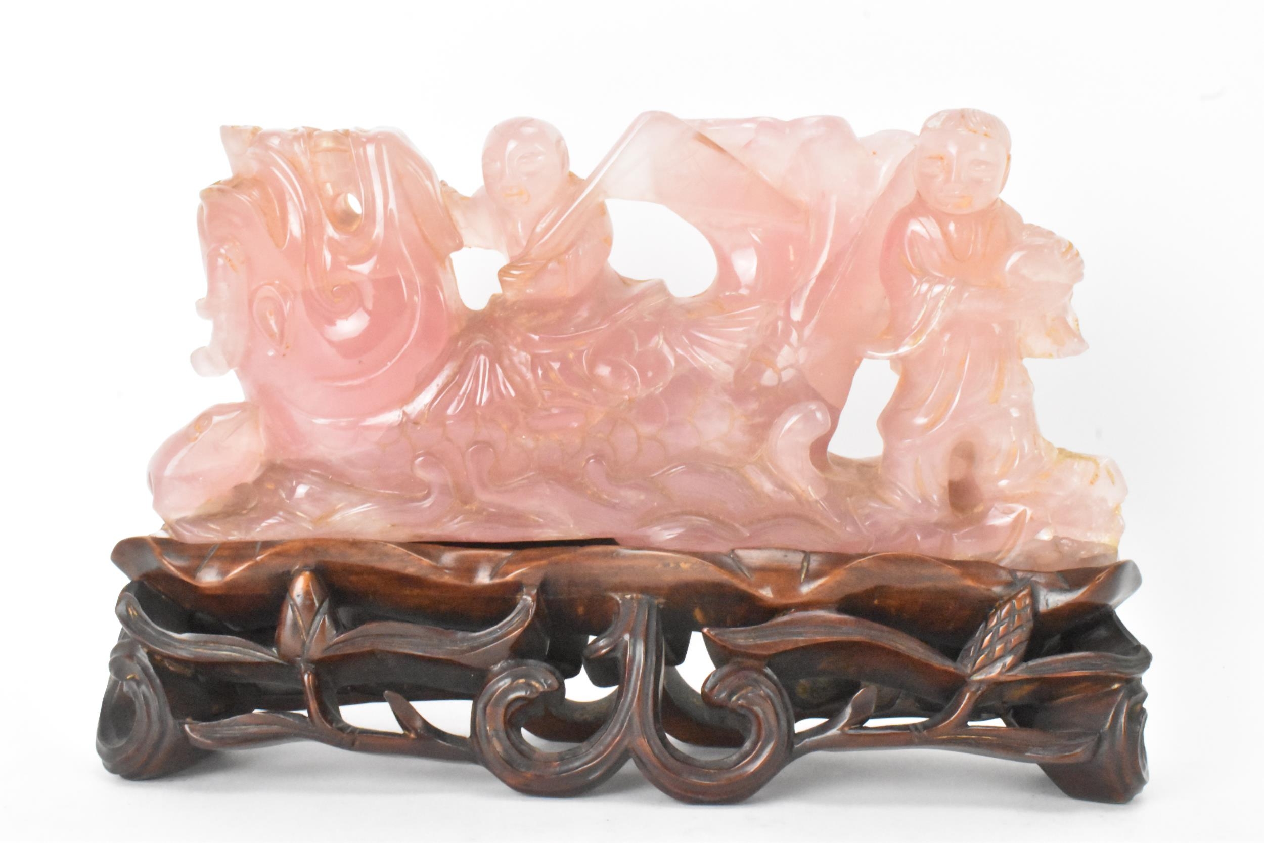 A Chinese 20th century rose quartz figural group of children in a nautical setting riding a sea
