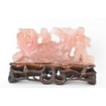 A Chinese 20th century rose quartz figural group of children in a nautical setting riding a sea