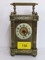 A brass carriage clock with an enamelled dial, and cast ornament Location: If there is no
