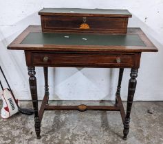 An Edwardian walnut writing desk having a storage compartment above a green leather top and drawer