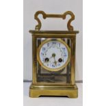 A large early 20th century brass cased carriage style clock with a painted dial and gong strike