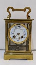 A large early 20th century brass cased carriage style clock with a painted dial and gong strike