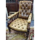 A late Victorian mahogany salon armchair having green leather button back upholstery and turned