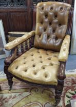 A late Victorian mahogany salon armchair having green leather button back upholstery and turned
