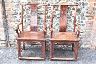 A pair of 20th century Chinese Ming style yoke back hardwood armchairs, with curved top rail and