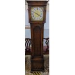 An early 20th century oak long case clock, striking on eight rods and having a gilt dial with