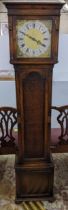 An early 20th century oak long case clock, striking on eight rods and having a gilt dial with