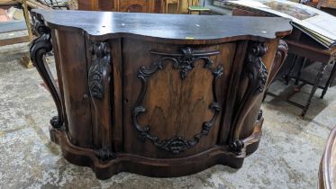 A Victorian rosewood sideboard having bow fronted doors, applied floral and scroll mouldings and