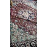 A Persian hand woven carpet having a red ground, central motif and a floral design 430cm x 330cm