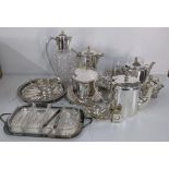 Silver plated items to include two teapots, a claret jug, a coffee pot, tray, miniature clock and