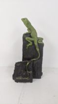 A pottery sculpture of a naturalistic of a iguana on a rock signed Oswaldo Merchor 31.5cm high
