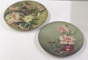 A pair of Victorian earthenware pottery chargers decorated with flowers, signed C Chambers to the
