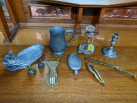 A selection of metalware to include a brass paper knife, miniature lady tea bells, paper clip in the