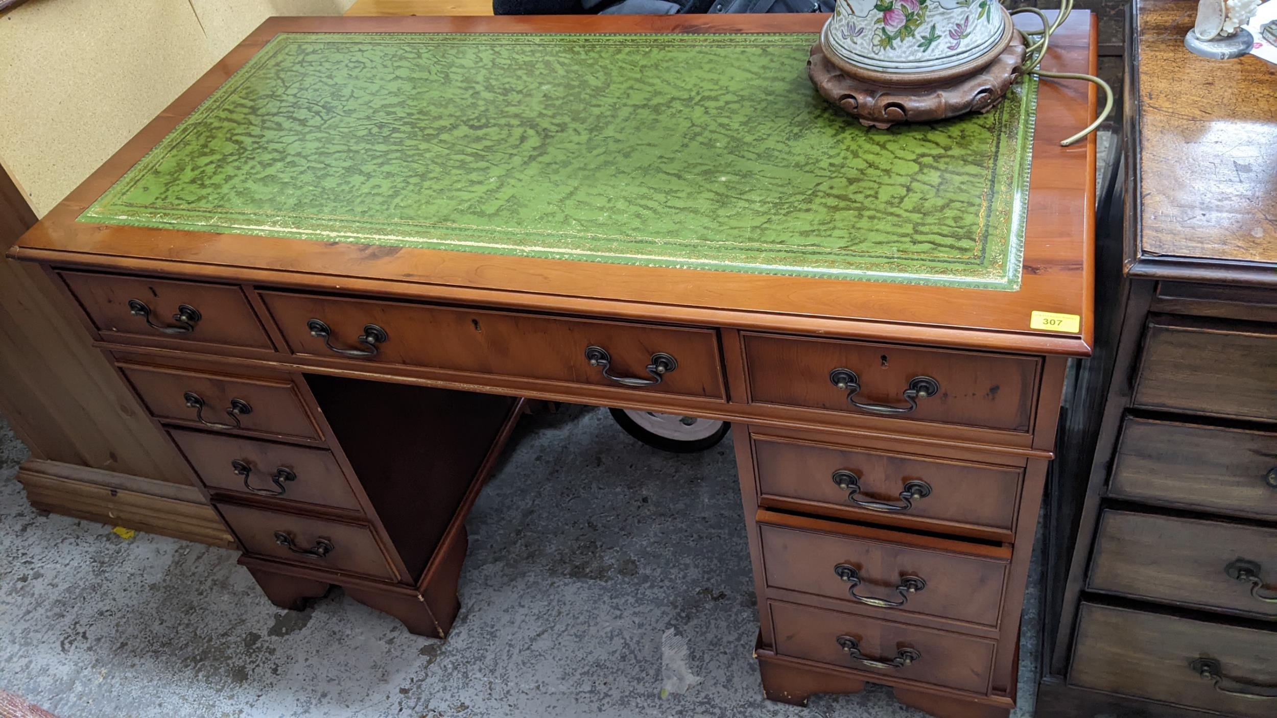 A late 20th century yew twin pedestal nine-drawer desk 79cm h x 122cm w Location: If there is no