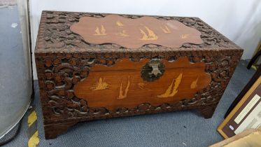 A mid 20th century Chinese camphor wood carved blanket chest inlaid with decorations of sailing